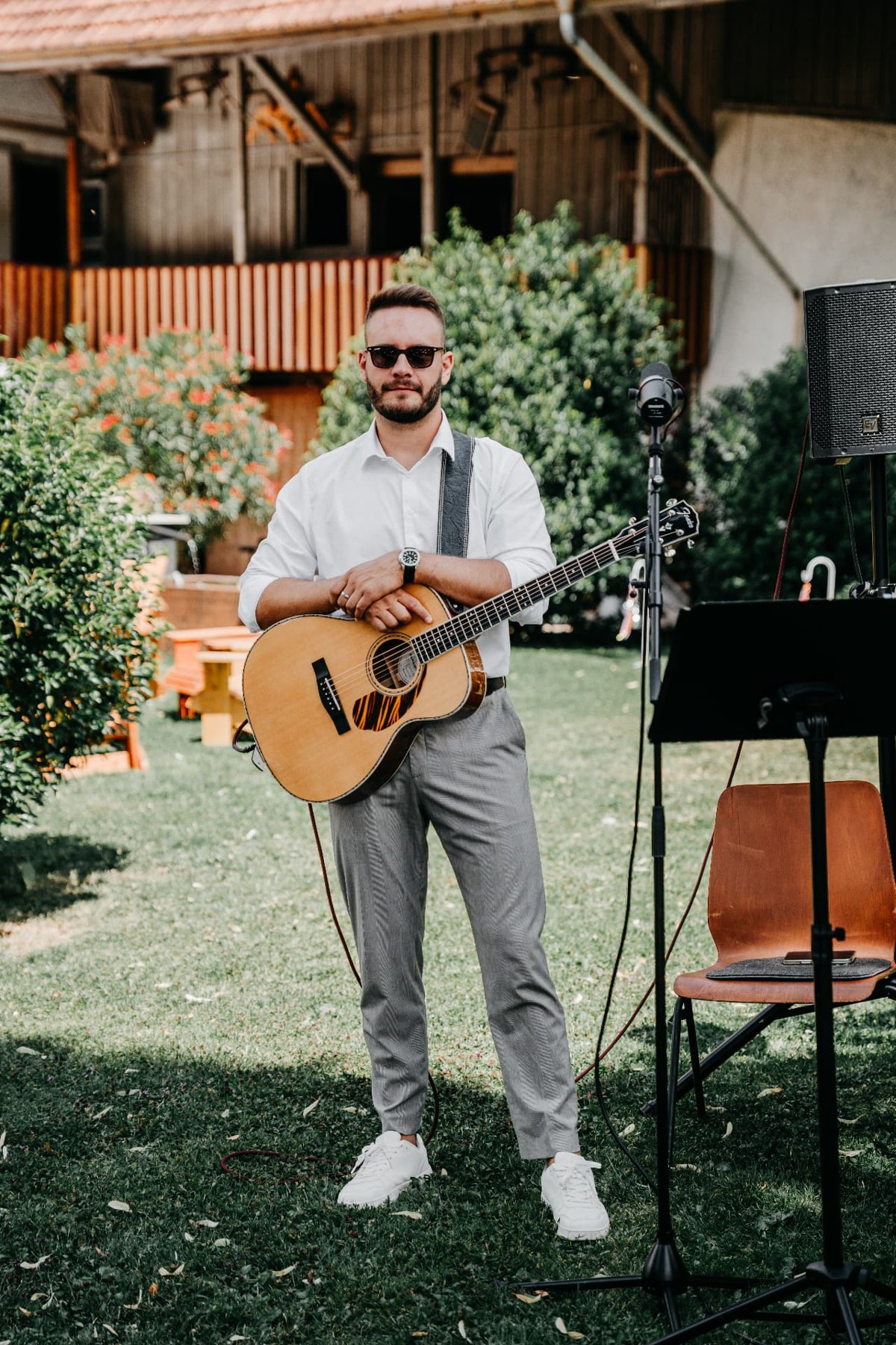 Dennis Ross mit Akustikgitarre im Garten vor dem Auftritt